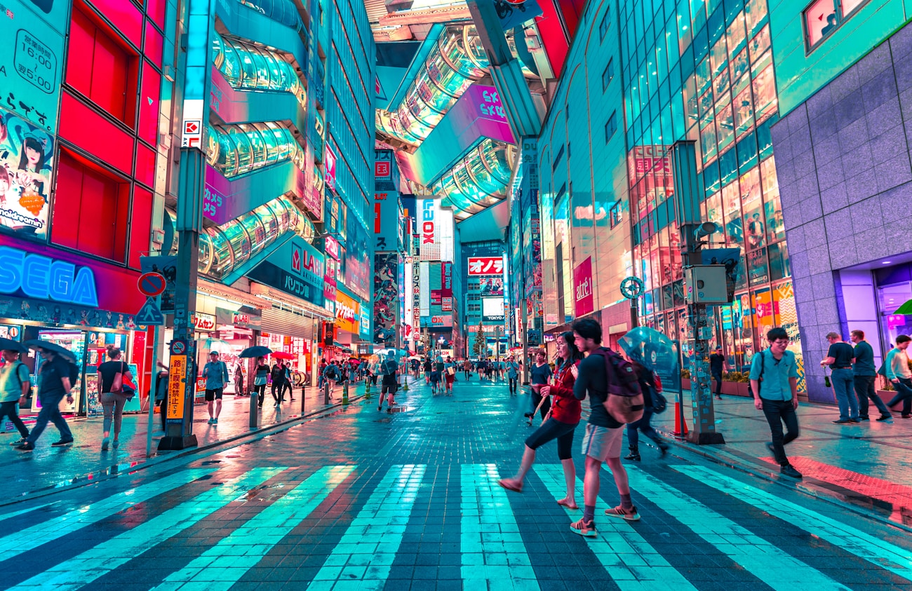 People exploring a colorful Tokyo street at night